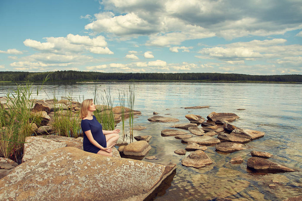 active young pregnant woman on shore of a lake - Photo, Image