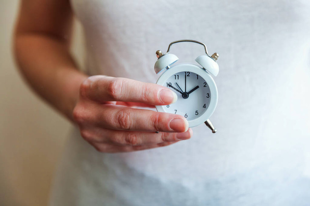 Female woman hands holding ringing twin bell vintage classic alarm clock - Foto, Bild
