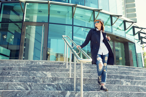 stylish woman in hat and sunglasses on the steps of shopping mall - Fotoğraf, Görsel