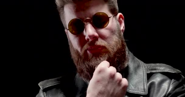 ernster Mann mit Heavy-Metal-Look kaut Tabak und berührt seinen Bart - Filmmaterial, Video