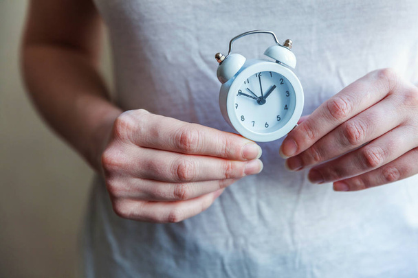 Female woman hands holding ringing twin bell vintage classic alarm clock - Photo, Image
