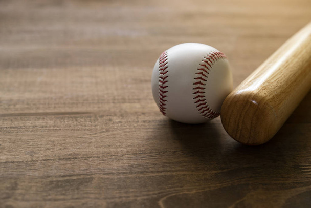 baseball and baseball bat on wooden table background, close up - Fotografie, Obrázek
