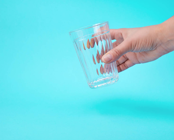 Рука женщины держит пустой прозрачный стакан
 - Фото, изображение