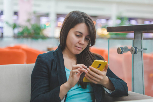 женщина с телефоном сидит в кафе
 - Фото, изображение