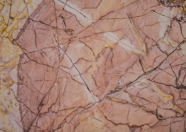 Abstracte achtergrond of het patroon tot een steen in een sectie, een roze en grijze tint met vlekken, scheuren en vlekken. Massief materiaal. - Foto, afbeelding