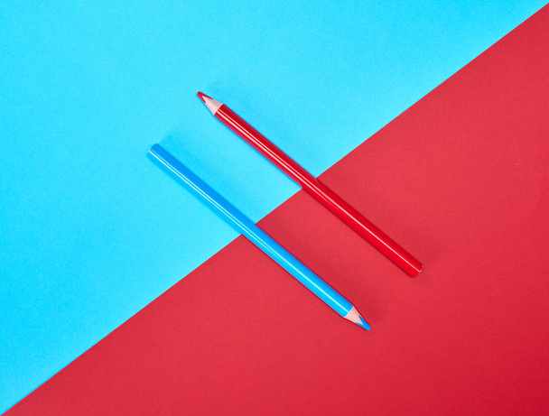 red and blue wooden pencils on color abstract background - Foto, imagen