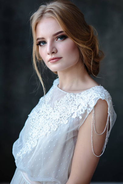 Bride blonde woman in a modern color wedding dress with elegant hair style and make up. Fashion beauty portrait over textured background - Fotografie, Obrázek