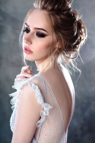 Bride blonde woman in a modern color wedding dress with elegant hair style and make up. Fashion beauty portrait over textured background - Foto, afbeelding