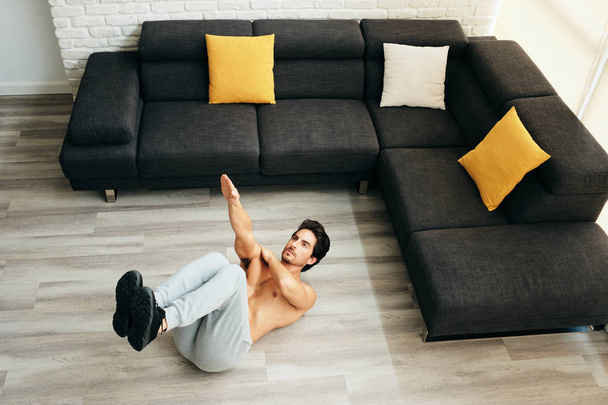 Volwassen Man opleiding Abs spieren thuis doen één Arm Crunches - Foto, afbeelding