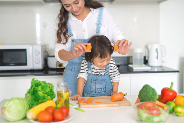 Šťastná rodina v kuchyni. Dcera matka a dítě se připravuje zelenina a ovoce. - Fotografie, Obrázek