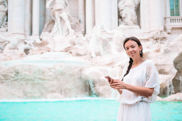 Красивая женщина смотрит на фонтан Треви во время поездки в Рим, Италия. Девочка наслаждается своим европейским отпуском
 - Фото, изображение