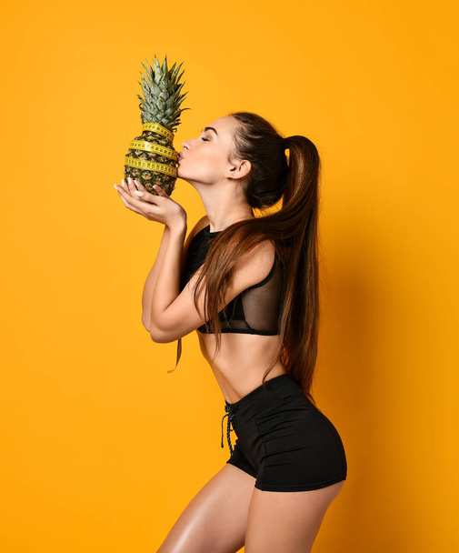 Sporty woman waist with measure tape and pineapple - Фото, изображение