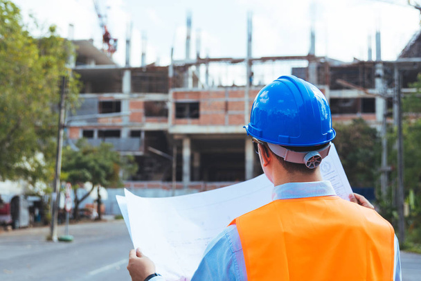 Азіатський людина інженер носіння шолома синій безпеки Перевірка роботи прогрес на будівельному майданчику. - Фото, зображення