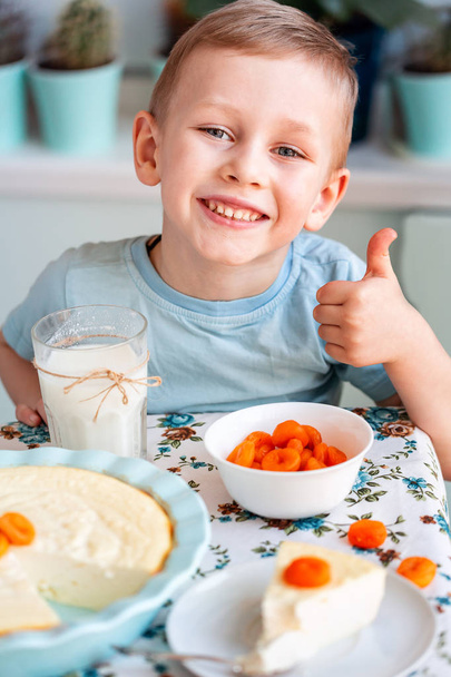 Beautiful little boy eating breakfast in kitchen at home - Фото, зображення