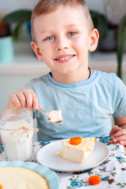 Beautiful little boy eating breakfast in kitchen at home - Фото, зображення