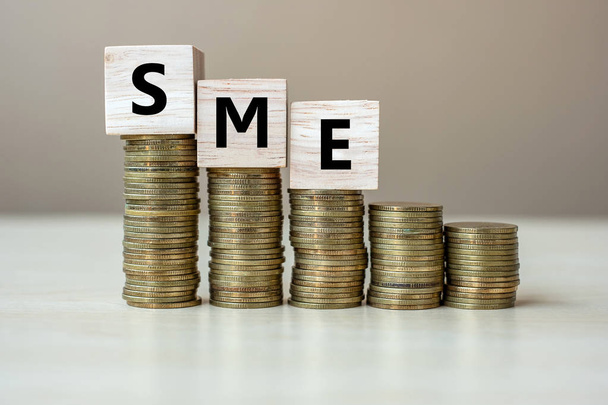 MŚP (małych średnich przedsiębiorstw) drewniany Kubik z złote monety na g - Zdjęcie, obraz