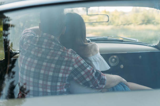 the man With girl is sitting at the wheel, the driver. view from the rear window. Rear view of tourist guy in car. Travel and summer vacation concepts. - Foto, Imagem