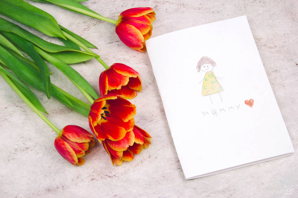 beautiful tulips and handmade card with kid's drawing  for Mother's Day on marble background, top view - 写真・画像