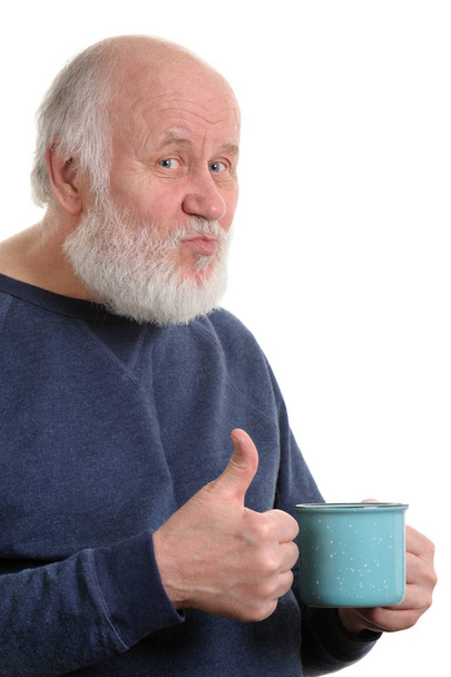 älterer Mann mit einer Tasse schlechten Tees oder Kaffees, der vereinzelt den Daumen nach oben zeigt - Foto, Bild
