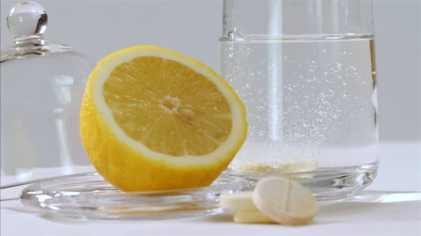 Šumivé vitamin C tablety bubliny ve sklenici vody na černém pozadí, 75 fps zpomalený pohyb - Záběry, video