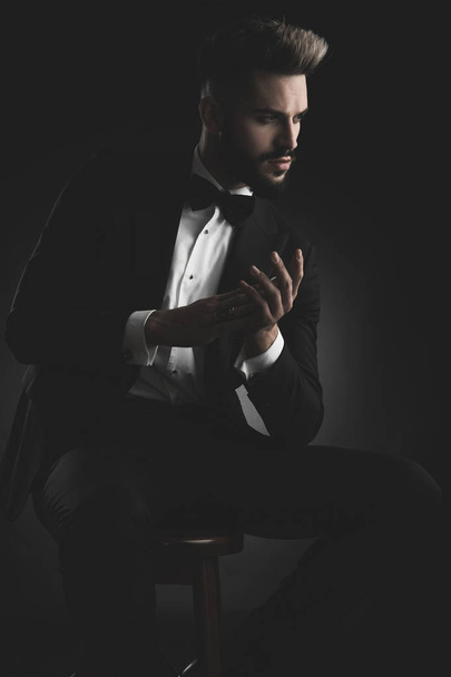 man in tuxedo sitting with hands together - Zdjęcie, obraz