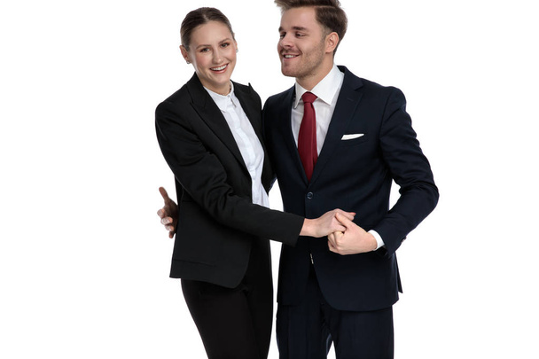 ζευγάρι στα κοστούμια των επιχειρήσεων κρατώντας τα χέρια μαζί - Φωτογραφία, εικόνα