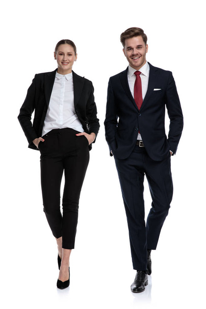 ビジネス スーツのポケットに手を歩いてのカップル  - 写真・画像