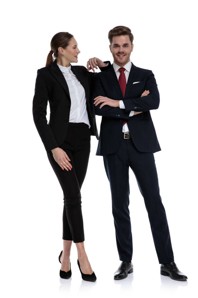 Paar im Businessanzug steht mit Ellbogen auf Schulter gestützt - Foto, Bild