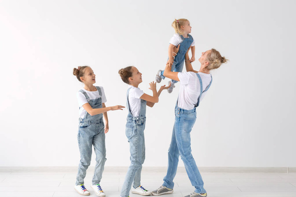 lidé, rodina a děti koncept - dvojčata a holčička s mamčou na bílém pozadí - Fotografie, Obrázek