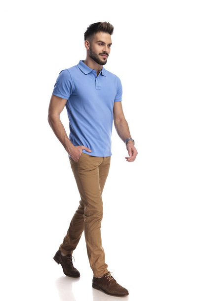 Casually dressed model wearing a light blue polo walking and loo - Photo, Image