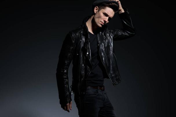 angry fashion man in leather jacket holding his hat - Photo, Image