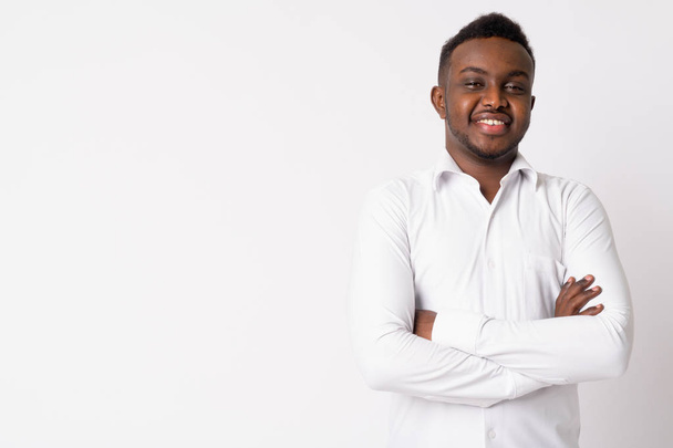 Portret van gelukkige jonge Afrikaanse zakenman glimlachend met gekruiste armen - Foto, afbeelding