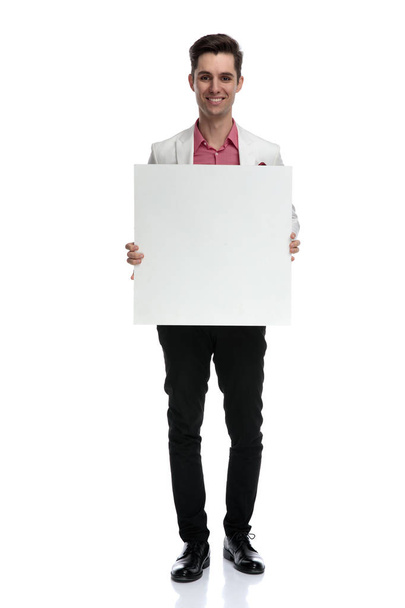smiling young man showing a blank board - Fotoğraf, Görsel