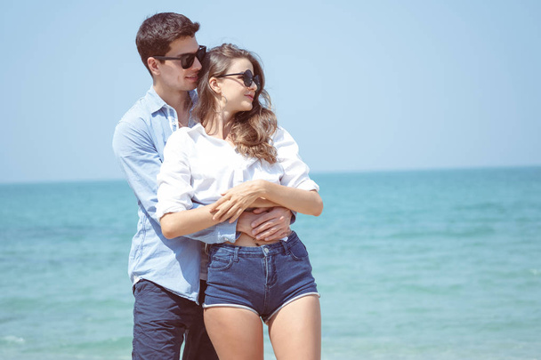 Happy Young Romantic Couple cuddling affectionate on the beach
 - Фото, изображение