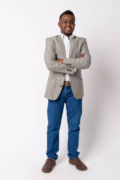 Full body shot de feliz joven empresario africano sonriendo con los brazos cruzados
 - Foto, imagen