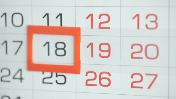 Womans hand in office changes date at wall calendar. Changes 18 to 19 - Footage, Video