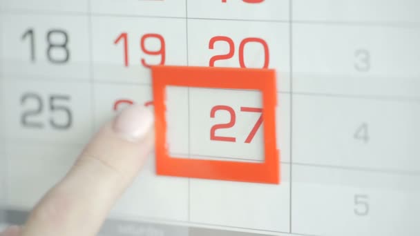 Womans hand in office changes date at wall calendar. Changes 26 to 27 - Footage, Video