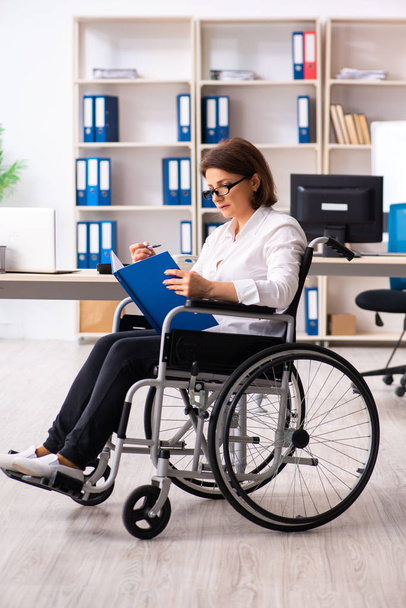 Employée en fauteuil roulant au bureau   - Photo, image