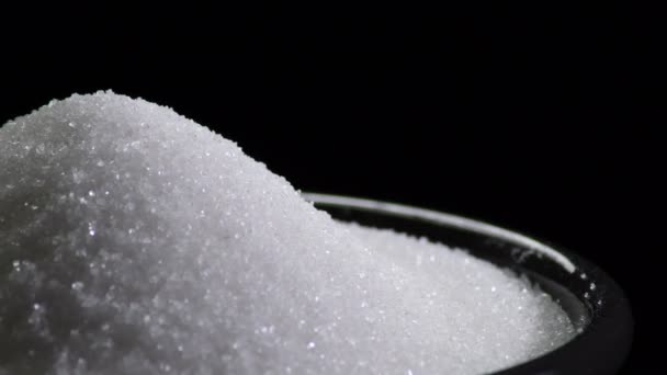 Vuori valkoista sokeria mustassa kulhossa
 - Materiaali, video