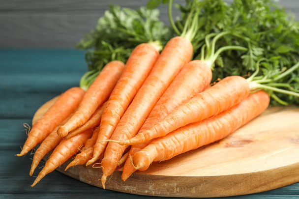 Обробна дошка зі стиглою морквою на дерев'яному столі
 - Фото, зображення