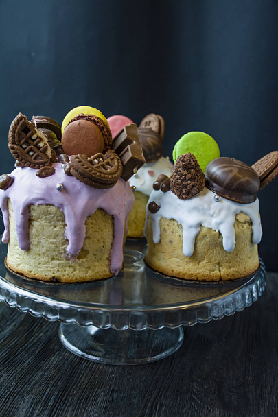 Pâques, les gâteaux de Pâques sont décorés avec du chocolat et des macarons. Kulich traditionnel, pain de Pâques. Vacances de printemps en mémoire de la résurrection du Christ. Fond sombre
. - Photo, image