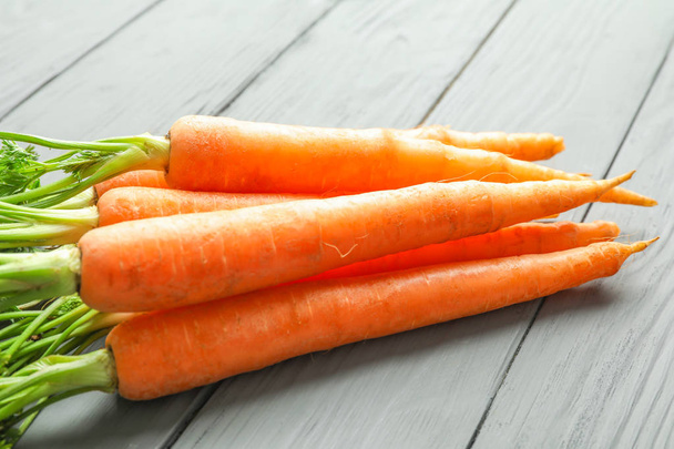 Стиглі моркви на дерев'яному фоні, крупним планом
 - Фото, зображення