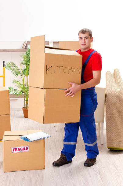 Молодой подрядчик с коробками работает в помещении
  - Фото, изображение