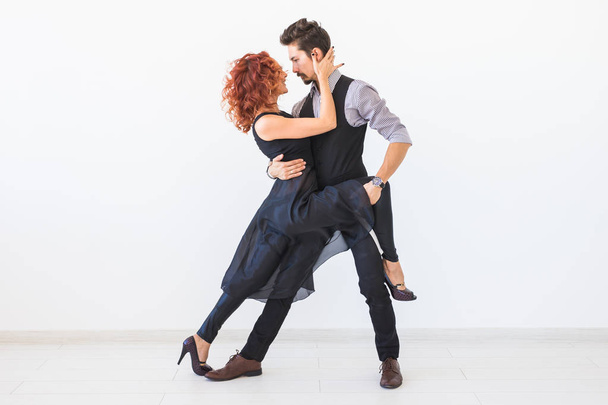 Dança social, bachata, kizomba, tango, salsa, conceito de pessoas - Casal jovem dançando sobre fundo branco
 - Foto, Imagem
