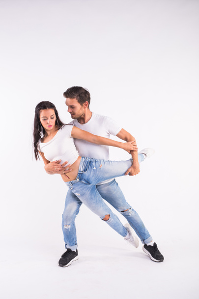 Young couple dancing social latin dance bachata, merengue, salsa. Two elegance pose on white background - Foto, afbeelding