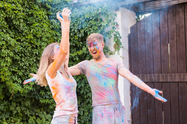 Freundschaft, Holi-Fest, People-Konzept - junges Paar spielt beim Holi-Fest mit Farben - Foto, Bild
