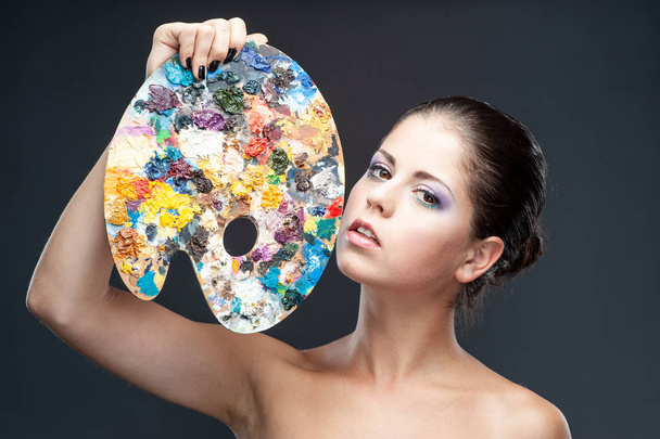 Girl with fantasy make-up holds a palette - Photo, Image