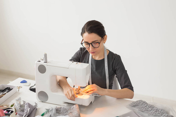 Pessoas, alfaiate e conceito de moda - Close up retrato de designer de moda local de trabalho com máquina de costura
 - Foto, Imagem