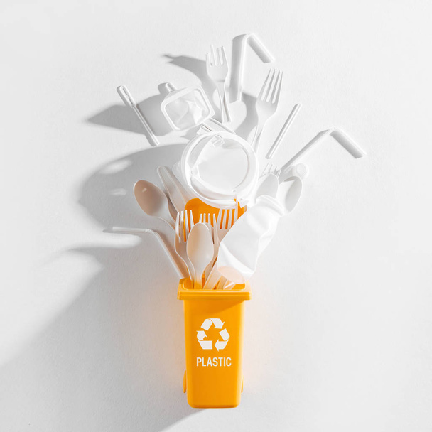 White single use plastic in garbage bin on  white background - Фото, изображение