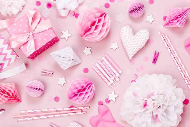 Decoraciones de papel rosa y blanco, pompones, dulces, corazones, regalos, confeti para la fiesta del bebé. Concepto de cumpleaños. Piso tendido, vista superior
 - Foto, imagen